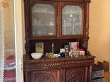 a wooden china cabinet in the corner of the room