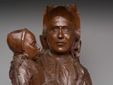 wooden statue of a woman holding a child in her arms