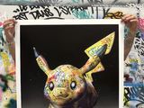 a man holding up a picture of a pokemon pikachu