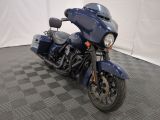 une moto bleue garée sur un sol à damier