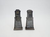 pair of antique metal telephone stands on a white surface