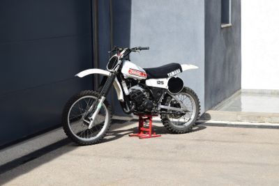 a dirt bike that is parked in front of a garage