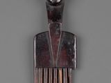 an image of a wooden comb with a man ' s face on it