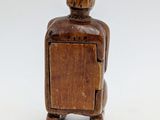 wooden figure of a man sitting in a chair with his back to the camera