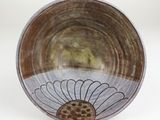 a brown and white bowl with a flower design on it