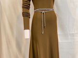 La robe est marron et comporte une ceinture à la taille.