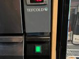 a refrigerator that has a digital clock on the front of it