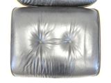 black leather lounge chair with a black cushion on top of it