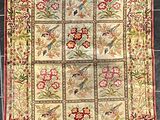 un gros plan sur un tapis orné d'oiseaux et de fleurs
