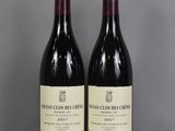 two bottles of wine sitting on top of a table next to each other
