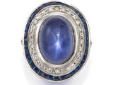un gros plan sur une bague sertie d'un saphir étoilé bleu et de diamants