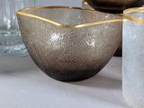three glass bowls and a glass vase on a table