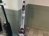 un aspirateur et une serpillière posés sur le sol d'une pièce