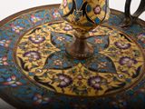 a gold cup sitting on top of a blue and gold plate