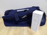 a blue bag with a bottle and a white box on the table