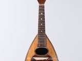 a guitar hanging from a string on a white wall