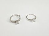 two silver rings with diamonds on them on a white surface