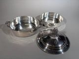 three silverplated dishes with lids and lids on a white surface
