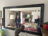 deux personnes debout devant un miroir dans un salon