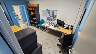 vue d'une pièce avec un bureau, une chaise et un écran d'ordinateur