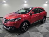 une voiture rouge est garée dans une grande pièce au sol en damier