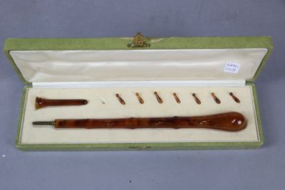 an image of a wooden pipe in a green box with a white lid
