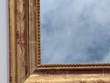a mirror hanging on a wall with a sky in the background