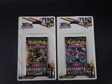 deux paquets de cartes à collectionner Pokémon posés sur une surface noire