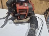 un ventilateur rouge et noir posé sur une table blanche