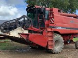 une moissonneuse-batteuse rouge qui est à l'arrêt dans la terre