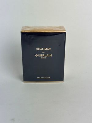 a close up of a box of perfume on a white surface