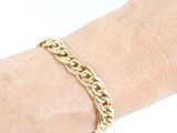 an image of a woman ' s hand wearing a gold chain bracelet