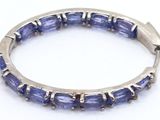 a close up of a bracelet with blue stones on a white surface