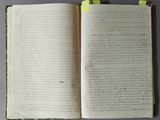an open book with writing on it sitting on top of a table