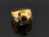 gros plan d'une bague en or avec trois pierres de couleurs différentes