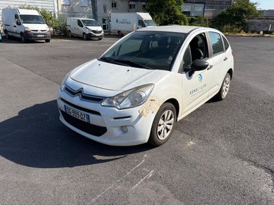 a small white car that is parked in a parking lot