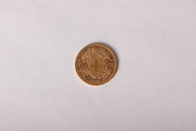 a close up of a gold coin on a white surface