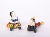 two figurines of a woman and a man sitting next to each other