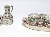 a small tray with cups and vases on it