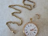 une montre à gousset en or avec une chaîne autour d'elle