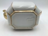 a close up of a white and gold container