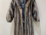 a fur coat on a mannequin stand in front of a wall
