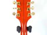 a guitar that is sitting up against a white wall
