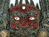 an image of a mask made of metal with red and blue beads