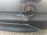 a reflection of a person in a mirror on the side of a car