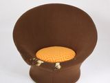une chaise marron avec un coussin jaune dessus