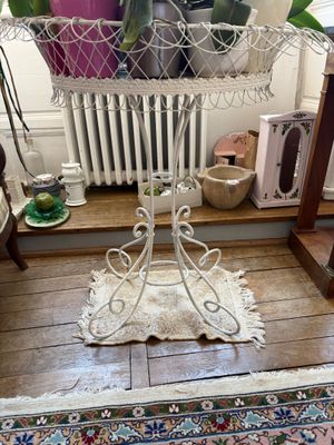 une plante dans un panier posé sur une table à côté d'un radiateur