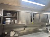 une grande cuisine équipée d'armoires et de plans de travail en inox