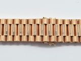 un gros plan d'un bracelet en bois posé sur une surface blanche