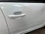 a white car that has a door handle on the side of it